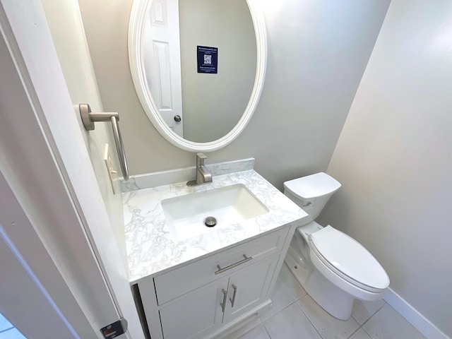 bathroom with toilet, vanity, and tile patterned floors