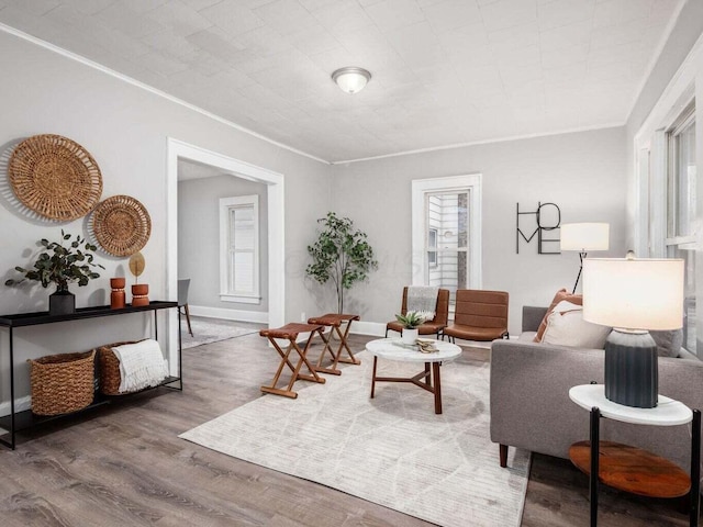 living room with a wealth of natural light, hardwood / wood-style floors, and crown molding