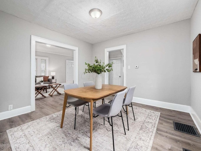 dining area featuring hardwood / wood-style floors and a textured ceiling