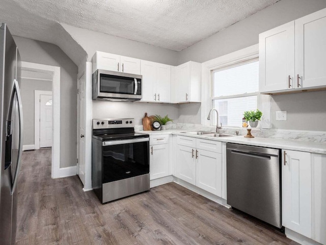 kitchen featuring white cabinets, appliances with stainless steel finishes, dark hardwood / wood-style flooring, and sink