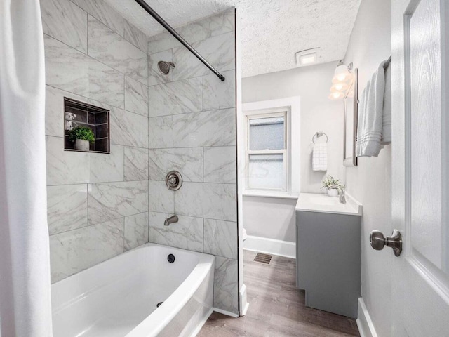 bathroom with shower / bath combo, vanity, hardwood / wood-style flooring, and a textured ceiling