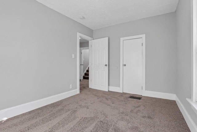 unfurnished bedroom featuring carpet and a textured ceiling