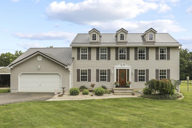 colonial inspired home with a front yard and a garage