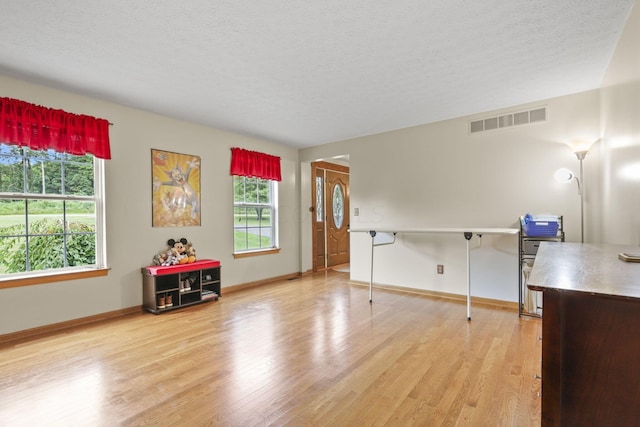 interior space featuring a textured ceiling and light wood-type flooring