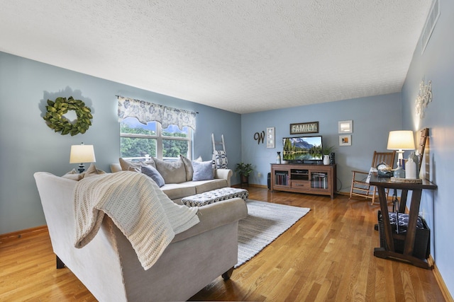 living room featuring light hardwood / wood-style floors and a textured ceiling