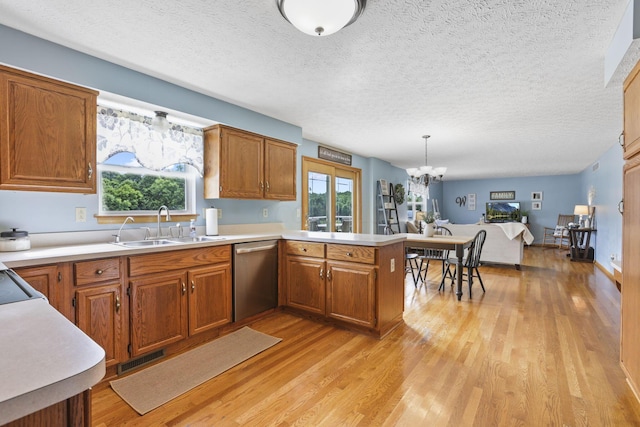 kitchen with dishwasher, plenty of natural light, pendant lighting, and light hardwood / wood-style floors