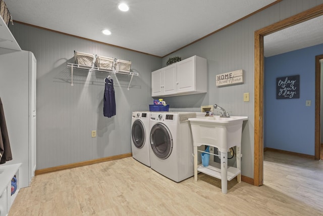 washroom with separate washer and dryer, light hardwood / wood-style flooring, cabinets, and ornamental molding