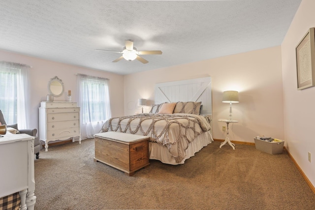 bedroom with multiple windows, ceiling fan, carpet floors, and a textured ceiling