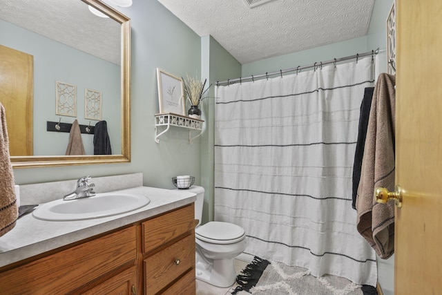 bathroom featuring walk in shower, vanity, a textured ceiling, tile patterned flooring, and toilet