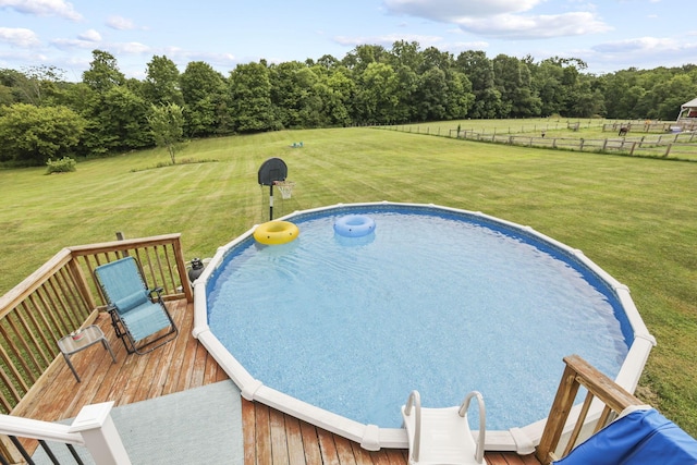 view of pool with a lawn and a wooden deck