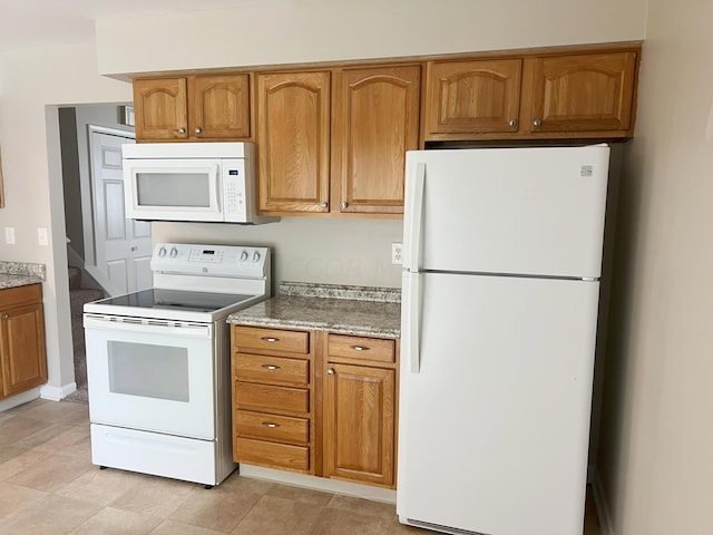 kitchen featuring light tile patterned floors and white appliances