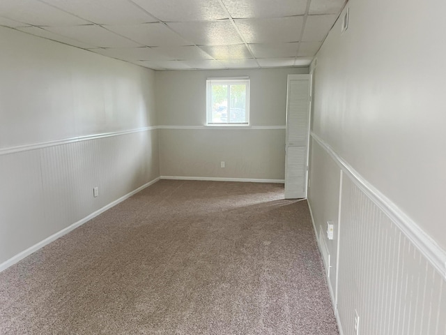 empty room featuring carpet flooring and a drop ceiling