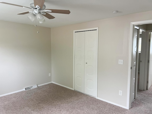 unfurnished bedroom with carpet, a closet, and ceiling fan