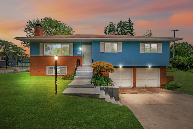 split foyer home featuring a garage and a yard