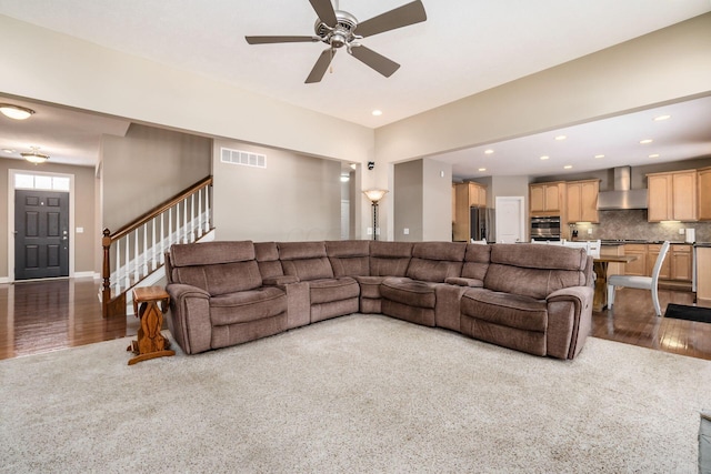 carpeted living room with ceiling fan