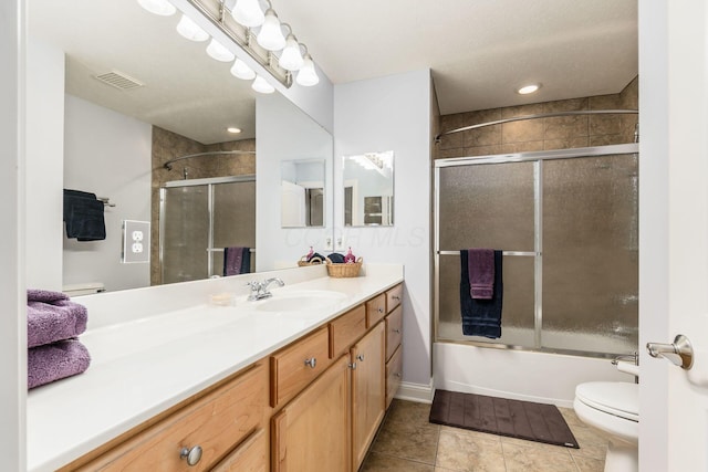 full bathroom with toilet, tile patterned flooring, vanity, and bath / shower combo with glass door