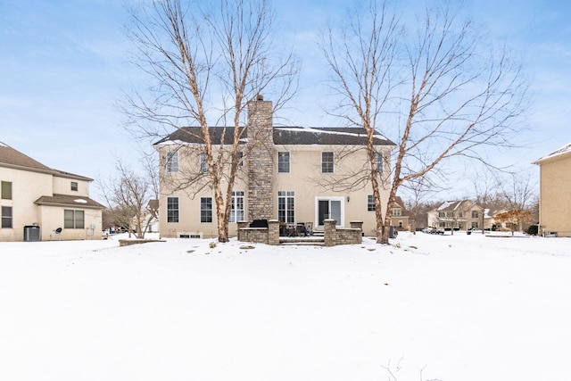 view of snow covered rear of property