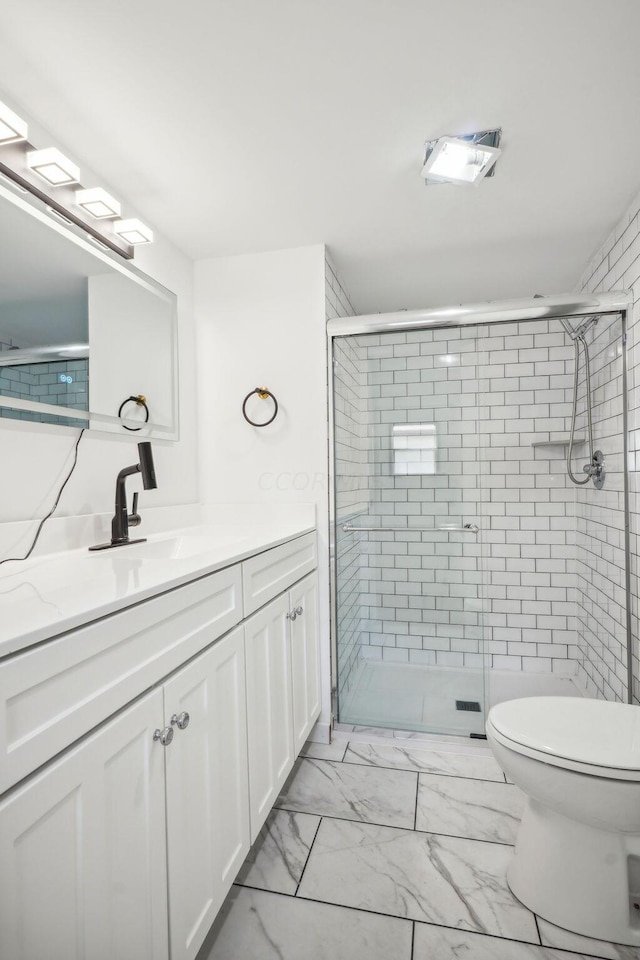 bathroom featuring an enclosed shower, vanity, and toilet