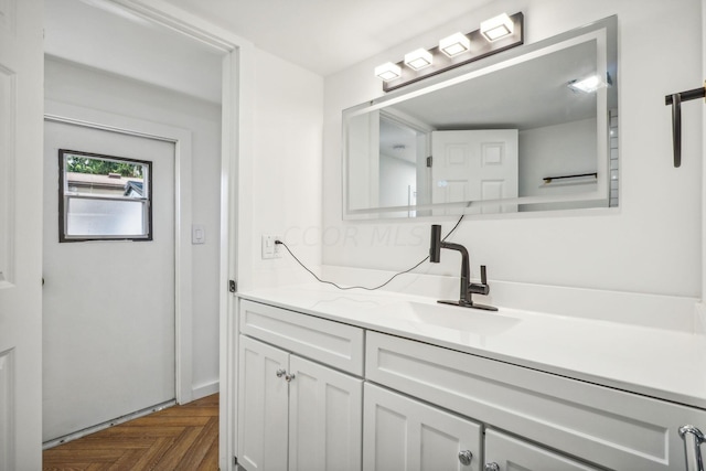 bathroom featuring parquet flooring and vanity