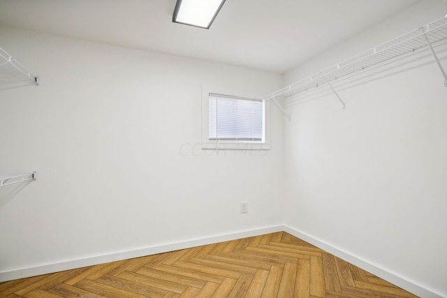 spacious closet featuring parquet floors