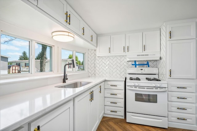 kitchen featuring sink, parquet floors, white range with gas stovetop, decorative backsplash, and white cabinets