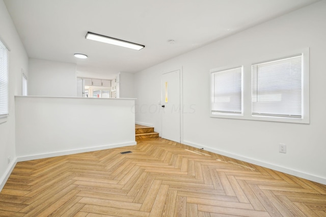 empty room featuring light parquet floors and a healthy amount of sunlight