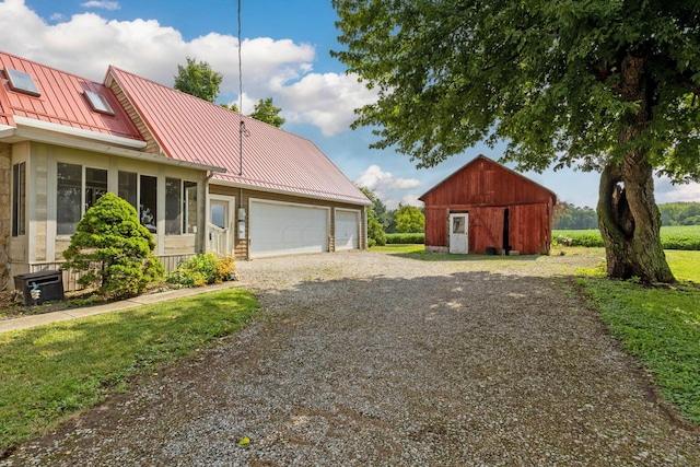 view of front of home featuring a front yard, central AC, a garage, and an outdoor structure