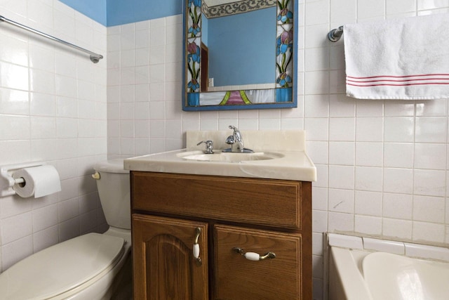 bathroom featuring vanity, tile walls, and toilet