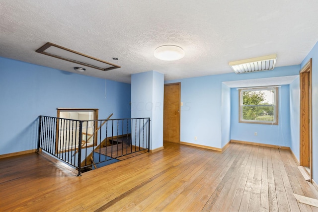 unfurnished room featuring hardwood / wood-style floors and a textured ceiling