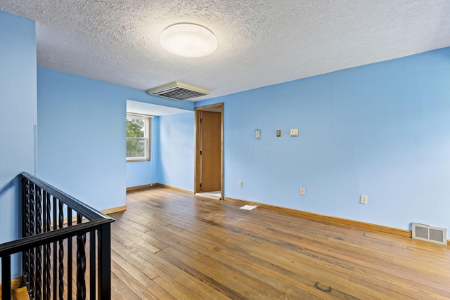 unfurnished room featuring a textured ceiling and hardwood / wood-style flooring