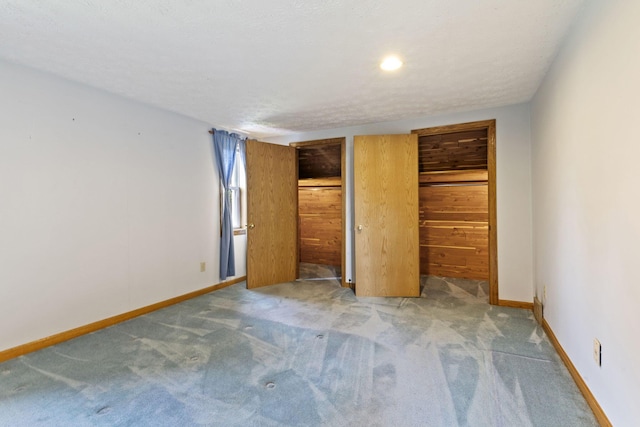 unfurnished bedroom with a textured ceiling, light carpet, and a closet