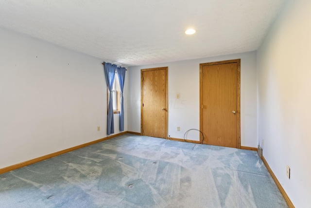 unfurnished bedroom featuring carpet flooring and a textured ceiling