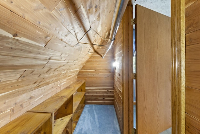 bonus room featuring lofted ceiling, dark carpet, and wooden walls