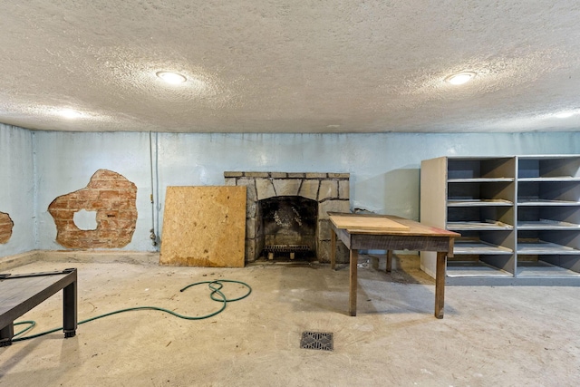 basement with a fireplace and a textured ceiling