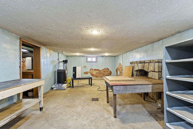 interior space with a workshop area, electric panel, concrete floors, and a textured ceiling