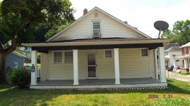 rear view of property with a lawn and covered porch