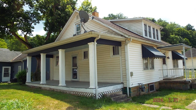 back of property featuring a lawn and a porch