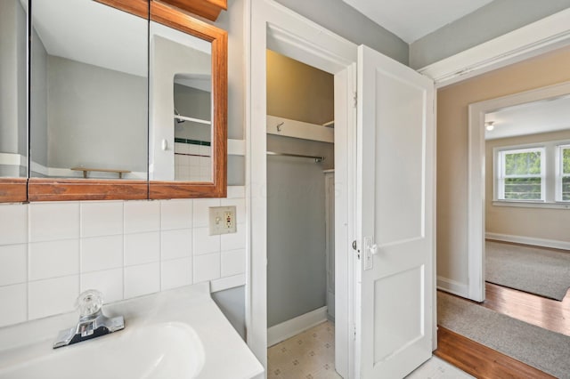 bathroom with decorative backsplash, wood-type flooring, and vanity