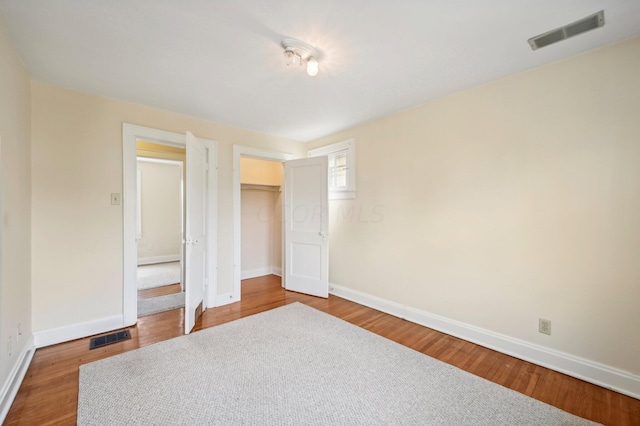 unfurnished bedroom with hardwood / wood-style floors and a closet