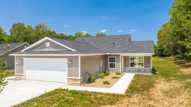 single story home with covered porch, a garage, and a front yard