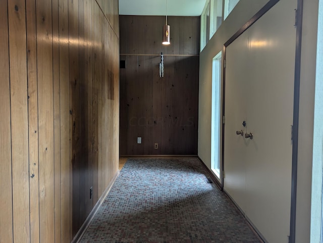 corridor with carpet flooring and wooden walls