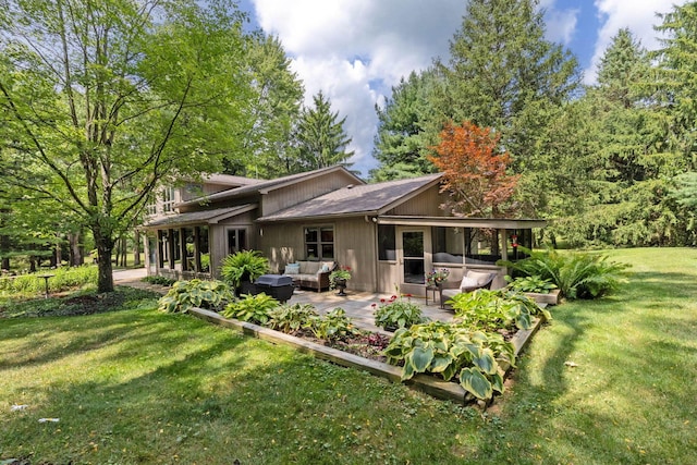 back of property with outdoor lounge area, a yard, and a patio