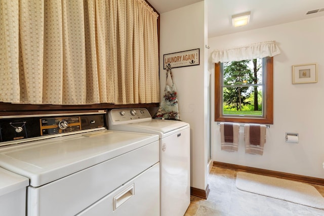 clothes washing area with light tile patterned floors and washing machine and clothes dryer