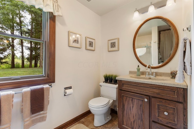 bathroom featuring tile patterned flooring, vanity, and toilet