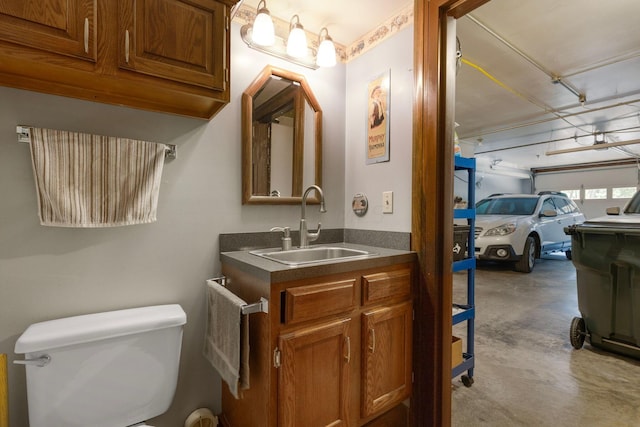 bathroom featuring concrete flooring, vanity, and toilet