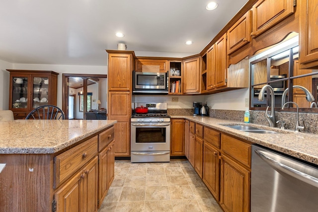 kitchen featuring light stone counters, sink, and appliances with stainless steel finishes