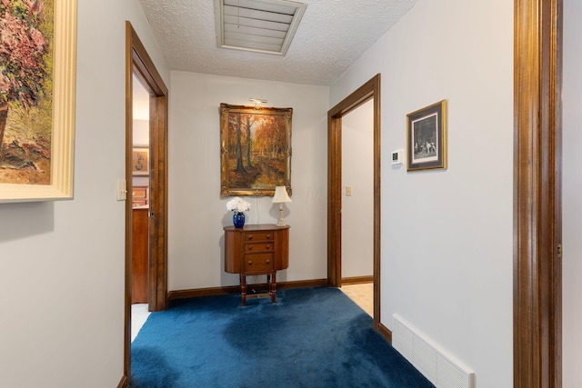 hallway with carpet and a textured ceiling