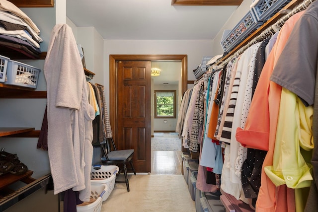 walk in closet with light colored carpet