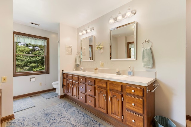 bathroom featuring tile patterned flooring, vanity, and toilet