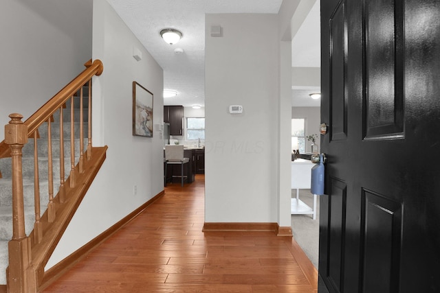 foyer entrance with wood-type flooring and a textured ceiling